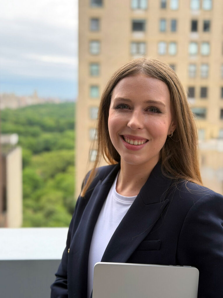 Grace Dunn holding a laptop on a New York City rooftop — Columbia University graduate and elite SAT, ACT, and PSAT tutor at Crownridge Coaching