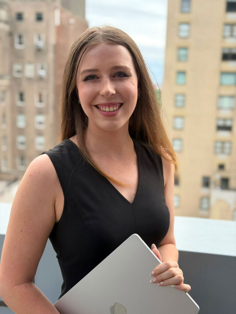 Grace Dunn holding a laptop on a New York City rooftop with Central Park in the background &mdash; founder of Crownridge Coaching and online SAT and ACT tutor