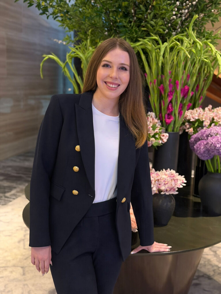 Grace Dunn standing in a hotel lobby in a navy blazer — founder of Crownridge Coaching available for a free SAT and ACT tutoring strategy call